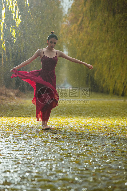 穿红色裙子的青年女人在户外跳芭蕾舞图片