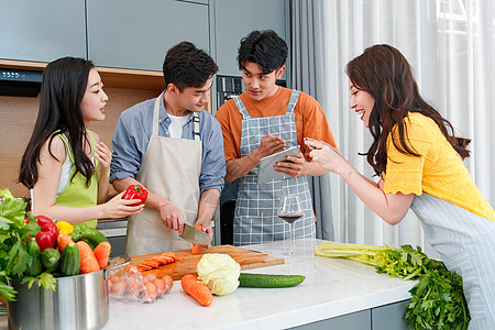 快乐的年轻人在厨房做饭照相高清图片