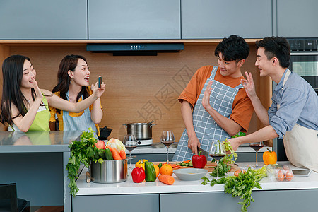 快乐的年轻人在厨房做饭照相图片