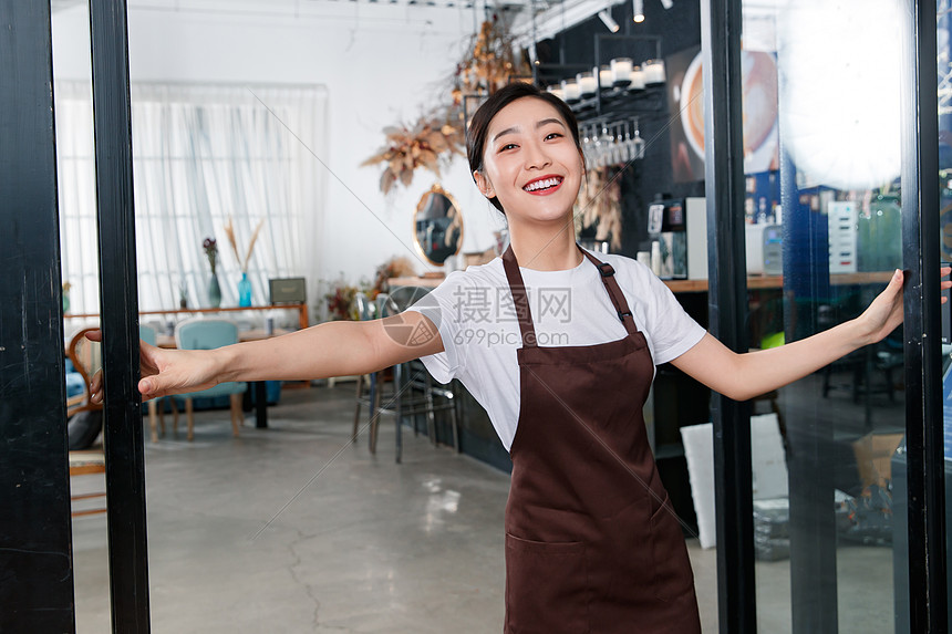 咖啡店门口迎接顾客的女服务员图片