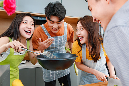 快乐的年轻人在厨房做饭图片