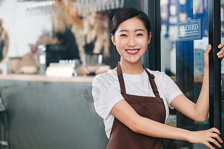 咖啡店门口迎接顾客的女服务员图片