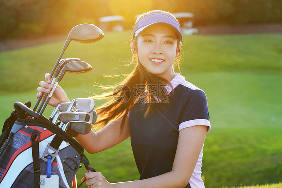 自信的青年女人取高尔夫球杆图片