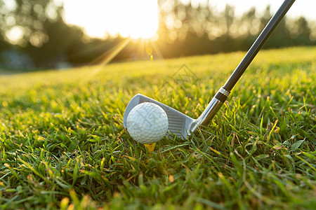 金色高尔夫球阳光下的高尔夫球杆与球背景