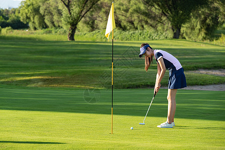 年轻女人打高尔夫图片