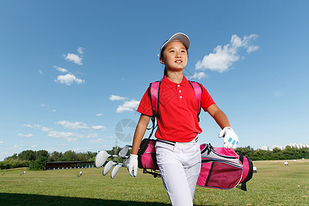 户外快乐儿童背着高尔夫球包图片