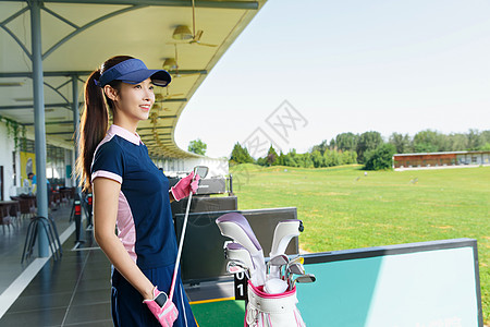 青年女人打高尔夫球高清图片