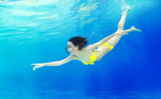 年轻女人在水下游泳图片