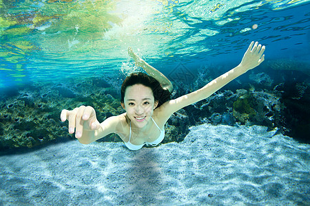 在水中游泳的人年轻女人在水下游泳背景