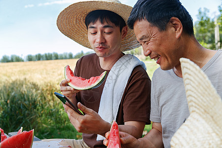 农民在田地旁休息吃西瓜图片