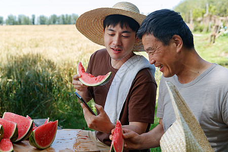 农民在田地旁休息吃西瓜高清图片