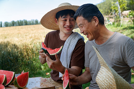 农民在田地旁休息吃西瓜图片