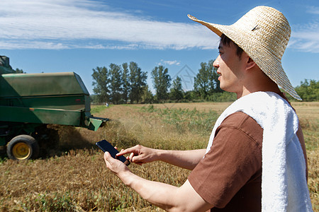 农民站在麦田里使用手机图片
