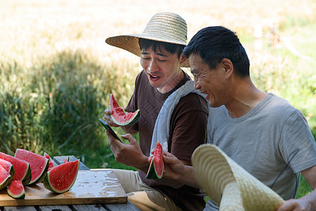 农民在田地旁休息吃西瓜图片