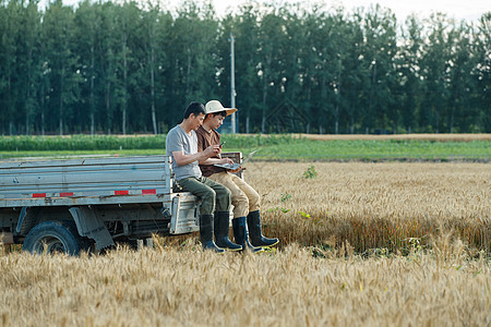 坐在车上使用手机的农民图片