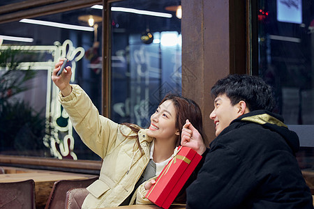 冬季年轻情侣拿着礼物自拍图片
