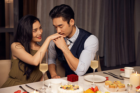 约会.烛光晚餐男性亲吻女性手背背景
