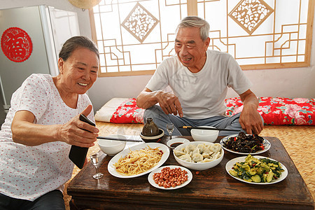 老年夫妇在家里吃饭看手机图片