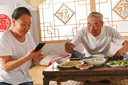 老年夫妇在家里吃饭看手机图片