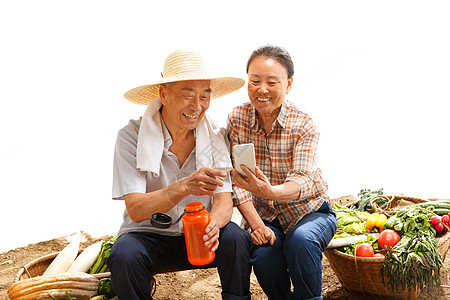 农民夫妇坐在田头看手机高清图片