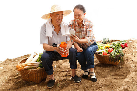 农民夫妇坐在田头看手机图片