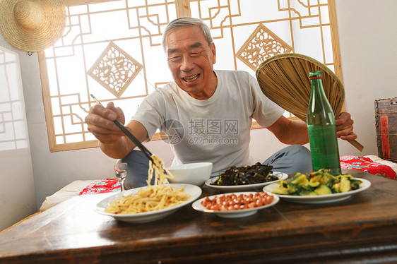 老年人坐在家里吃饭图片