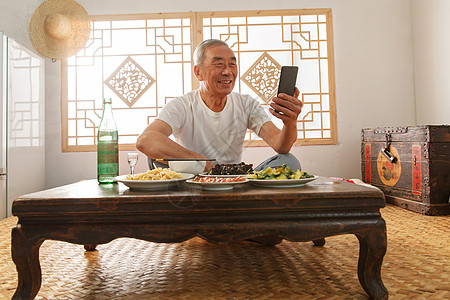 老年人坐在家里吃饭看手机图片