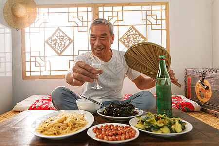 老年人坐在家里喝酒吃饭图片