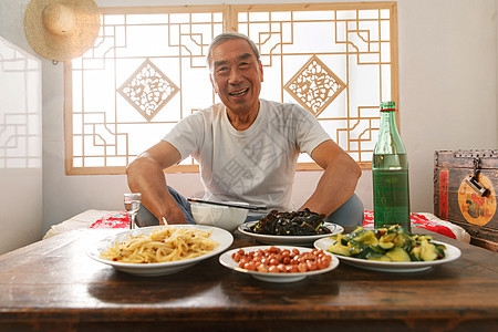 老年人坐在家里喝酒吃饭图片