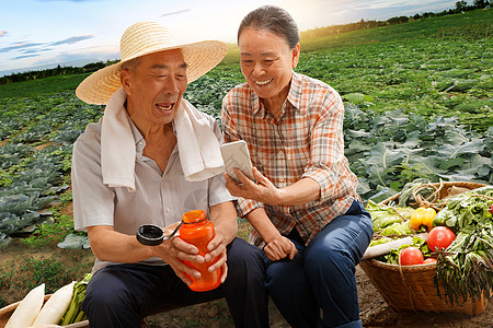 农民夫妇坐在田头看手机图片