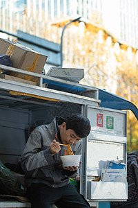 快递员坐在快递车上吃饭图片