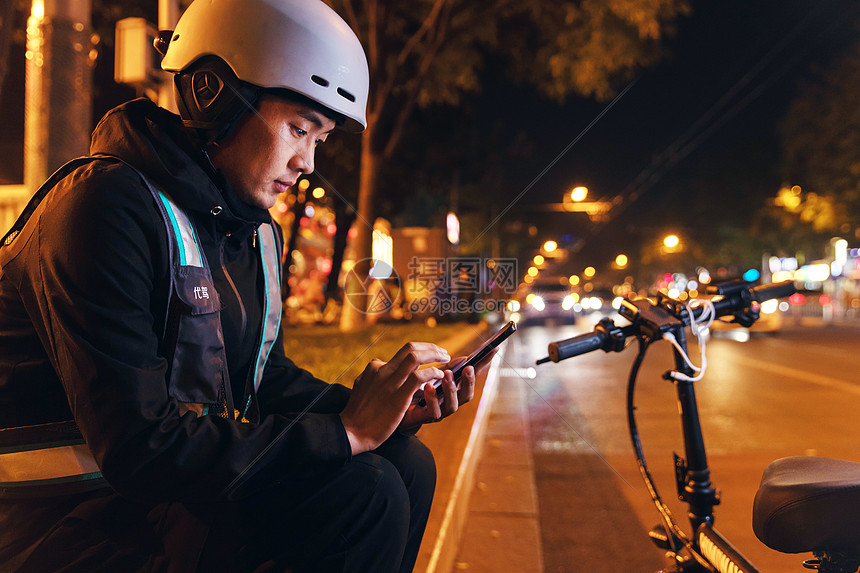 夜晚路边等待订单的代驾员图片