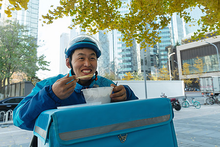 外卖员在街道旁吃饭休息高清图片