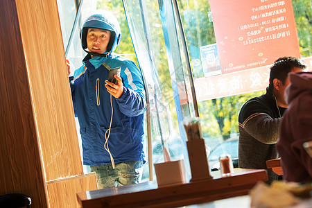 餐厅门口等待取餐的外卖员图片素材