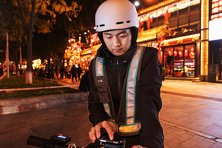 夜晚餐厅外等待订单的代驾员高清图片