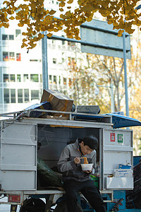 快递员坐在快递车上吃饭图片