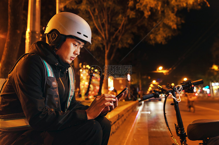 夜晚路边等待订单的代驾员图片