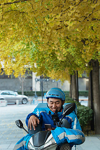 外卖员坐在摩托车上休息图片