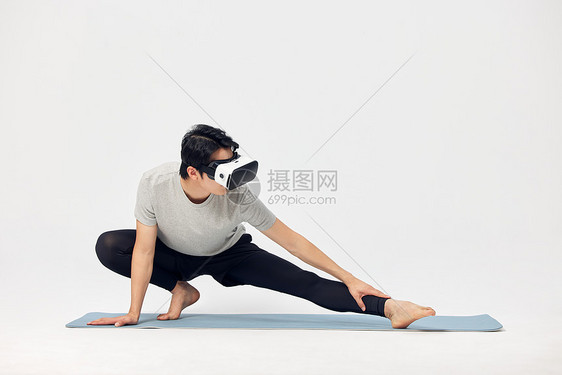 戴着vr眼镜练习瑜伽的男性图片