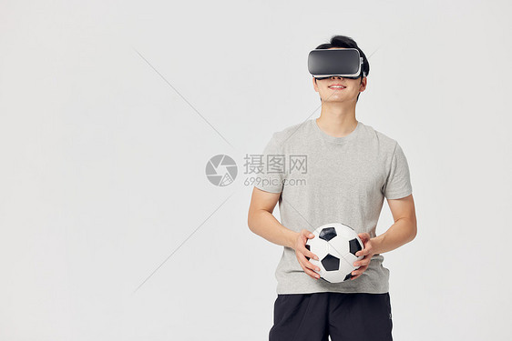 男性戴着vr眼镜玩足球运动游戏图片