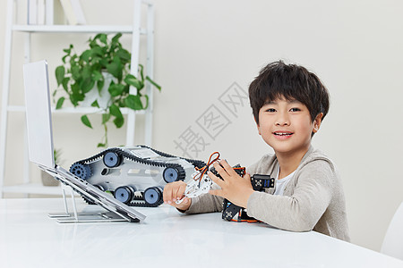 电子玩具学习编程机器人的小男孩形象背景