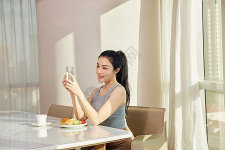 美女早晨坐在客厅享用早餐图片