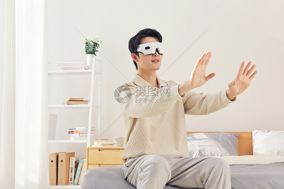 男性在卧室体验vr虚拟现实图片