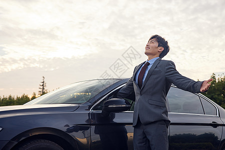 站在车边放松的商务男性图片