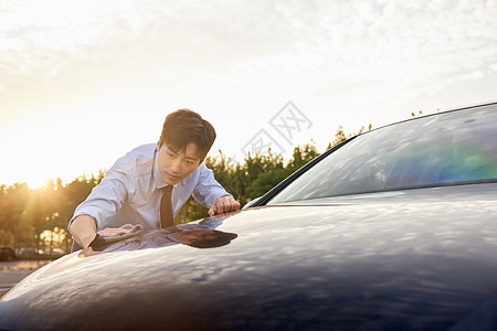 白领男性擦拭汽车外部漆面背景
