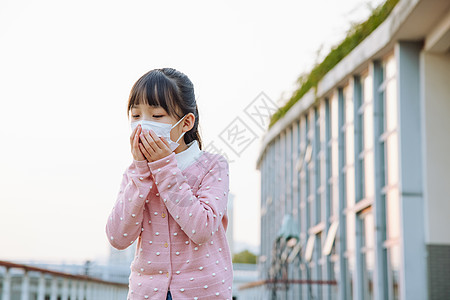 户外咳嗽戴口罩的小女孩高清图片