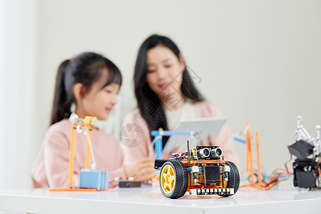 儿童ai妈妈和女儿一起学习操作机器人编程背景