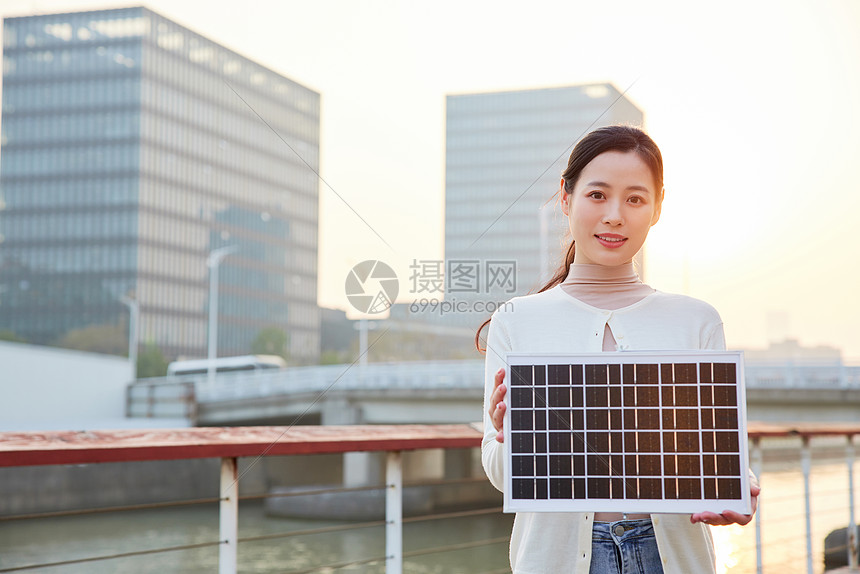 青年女性手拿太阳能板图片
