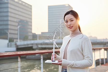 青年女性手拿太阳能风车模型图片