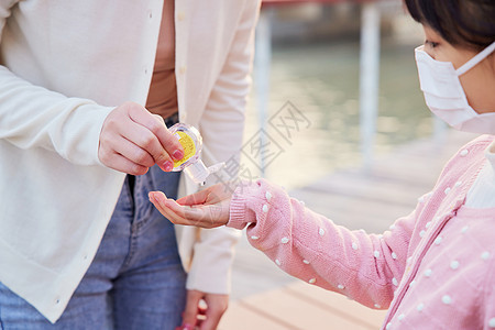 户外的母女使用凝胶护手消毒特写图片